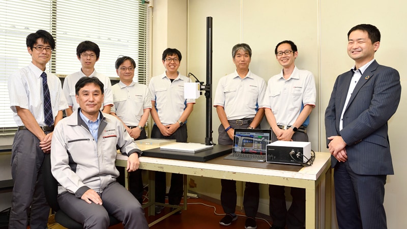 超音波光探傷装置を囲むプロジェクトチームメンバー