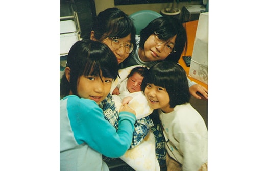 生まれたばかりの末っ子長男を囲む3姉妹。