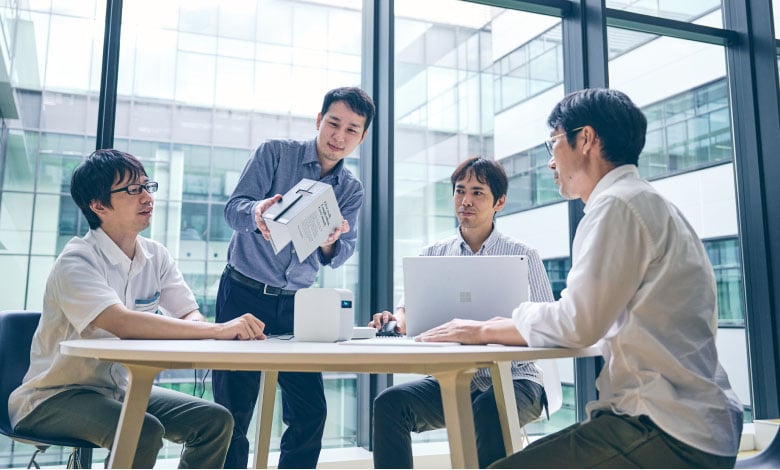 未来研究2：4人でプロトタイプを囲んで検討している