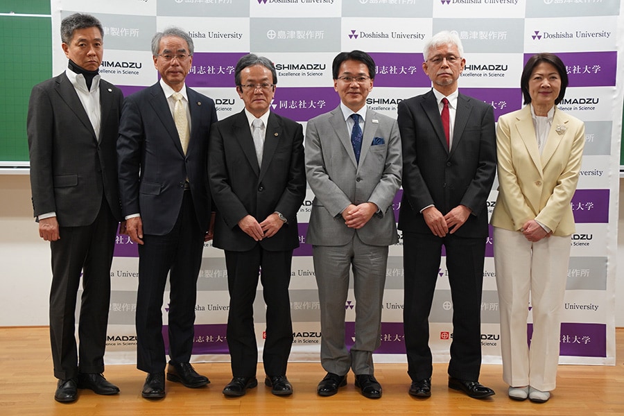 左から島津製作所 常務執行役員 青山恵則、代表取締役社長 山本靖則、代表取締役会長 上田輝久、同志社大学 小原克博学長、柿本昭人副学長・教育支援機構長、野口範子 生命医科学部教授