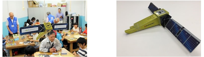 写真２　当社製回折格子を搭載した分光観測衛星「ひさき」の模型を作る「工房」では社員が講師を務める