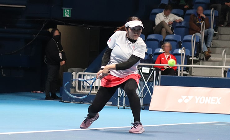 左足を深く踏み込みバックハンドストロークを打ちにいく左利きの菰方選手