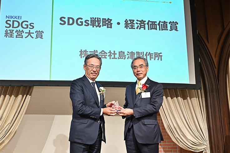 「SDGs戦略・経済価値賞」のトロフィーを受け取る当社代表取締役社長 山本靖則