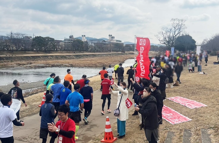 鴨川河川敷の「応援コーナー」にて、ランナーに声援を送る社員