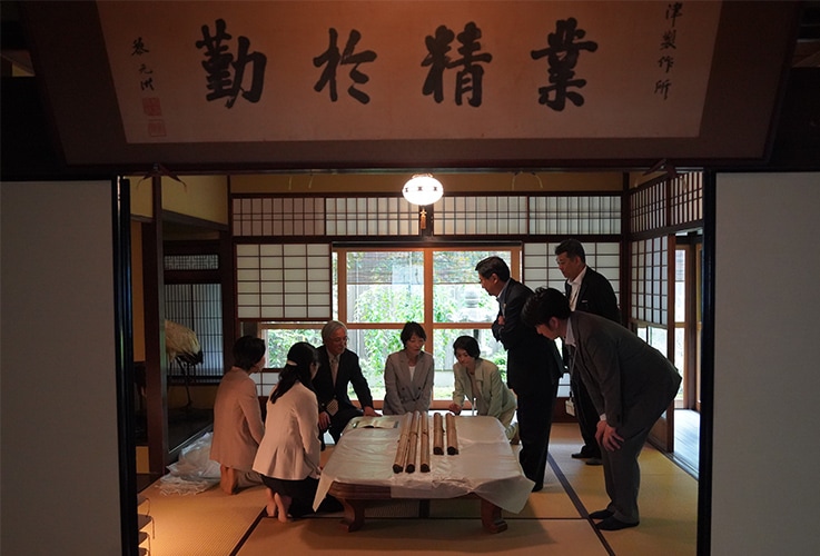 資料館内の島津源蔵の居室で、寄贈された掛図を囲む関係者
