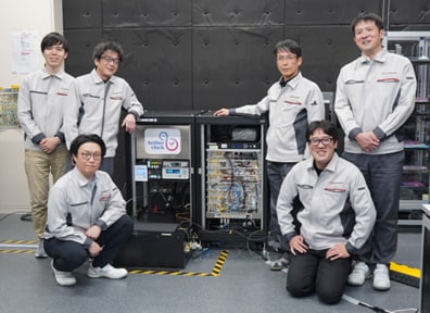 光格子時計「Aetherclock OC020」とプロジェクトメンバー。後列左から、二五和樹、古宮哲夫、東條公資、松花文太。前列左から酒井裕也、村松尚（いずれも島津製作所 基盤技術研究所）