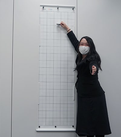 開発したスクリーンの前で使い方を説明する川崎 