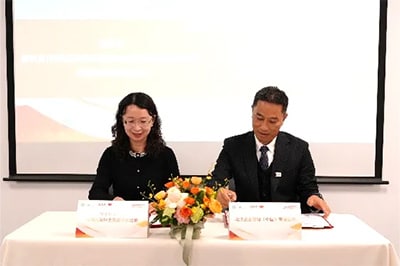 調印式にて協定書に署名をする代表者。環境基準・リスク管理全国重点実験室 赵晓丽（Zhao Xiaoli）副主任（左）とSSL 分析計測事業部 営業統括2部 統括部長 朱精华（Zhu Jinghua）