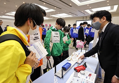 企業出展コーナーで実験キット 力学台車「スマートカート」を演示する島津理化の社員 