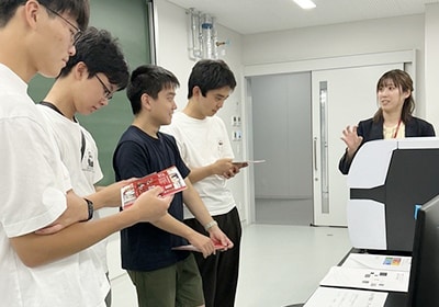 「液体で電気泳動ができるのですか？」研究現場で使われる分析装置を前に、次々と質問を投げかける参加者たち